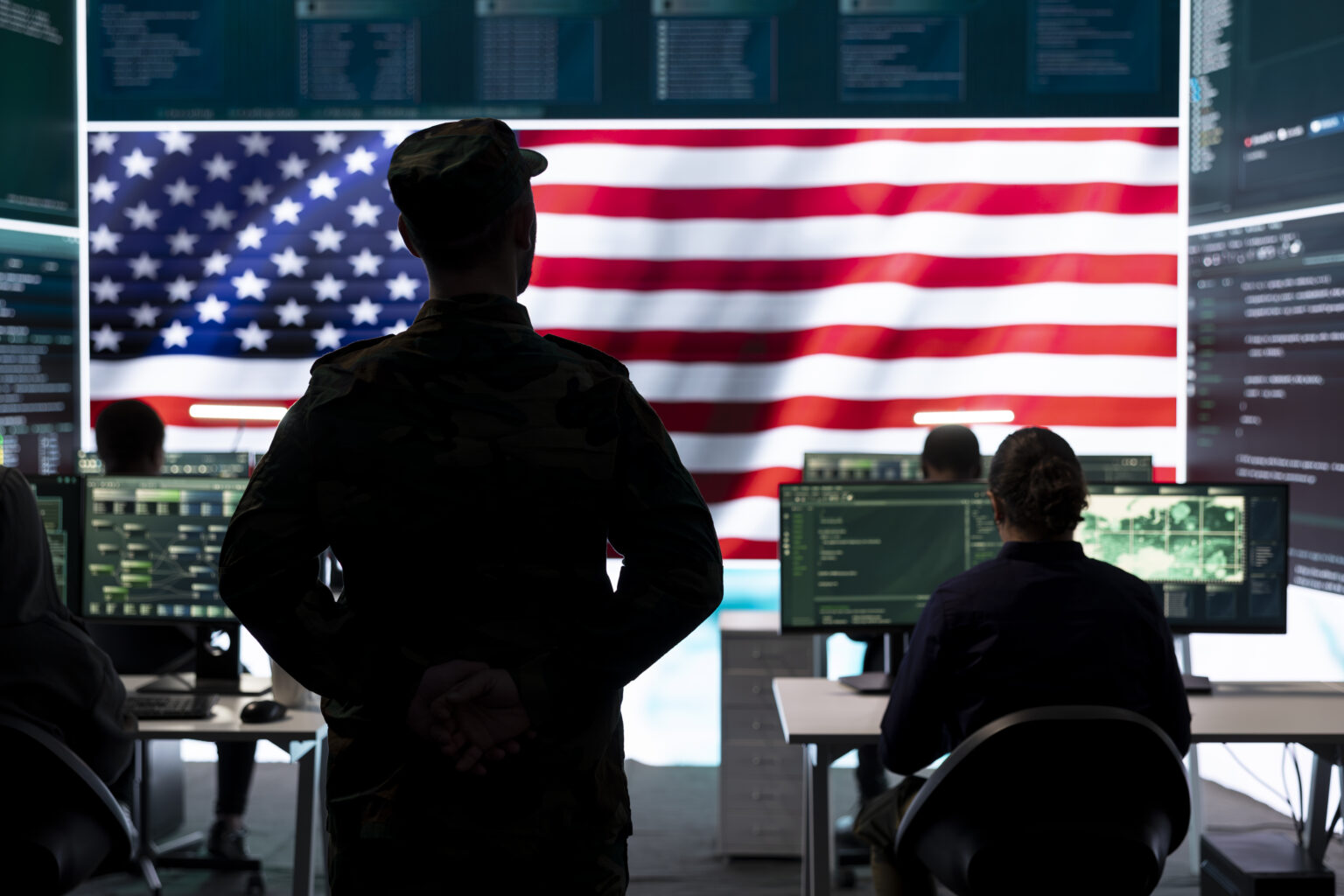 American military personnel ensuring servers protection and classified information, protecting state secrets in high tech agency office. Army soldier supervises hacking activity.